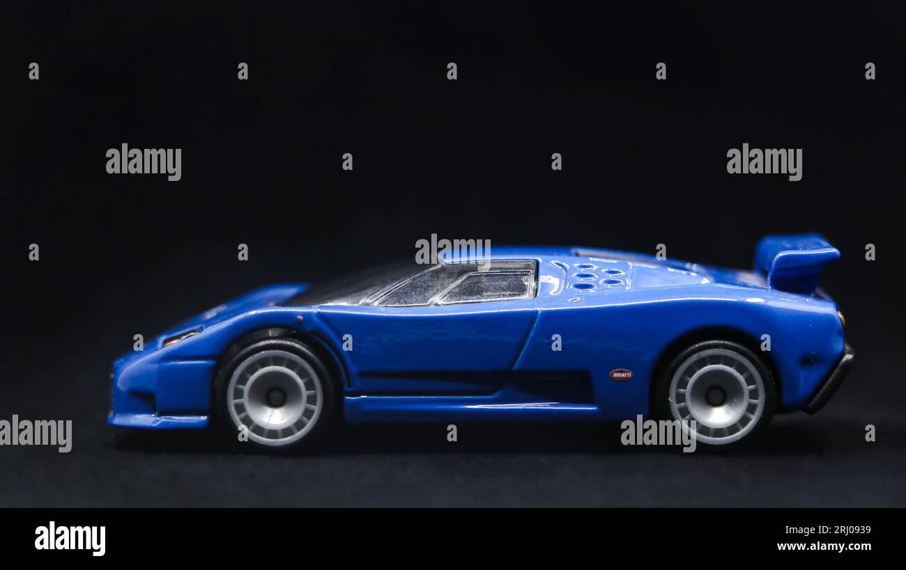 a collector's blue bugatti EB110 super sport car toy in small scale isolated in a black background Stock Photo