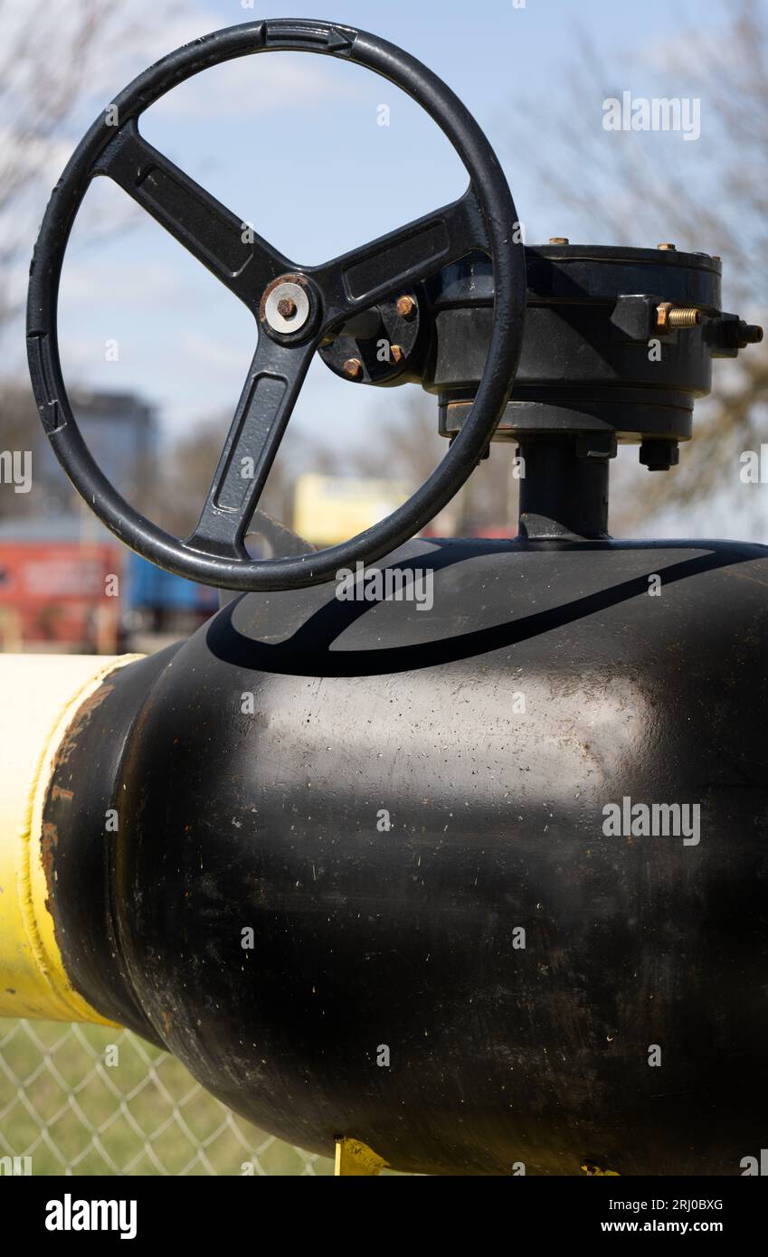 Yellow gas pipe with valve. Transportation, delivery of gas to consumers. Manual shut-off valve service with pipeline gas. Gasification land plots. Th Stock Photo