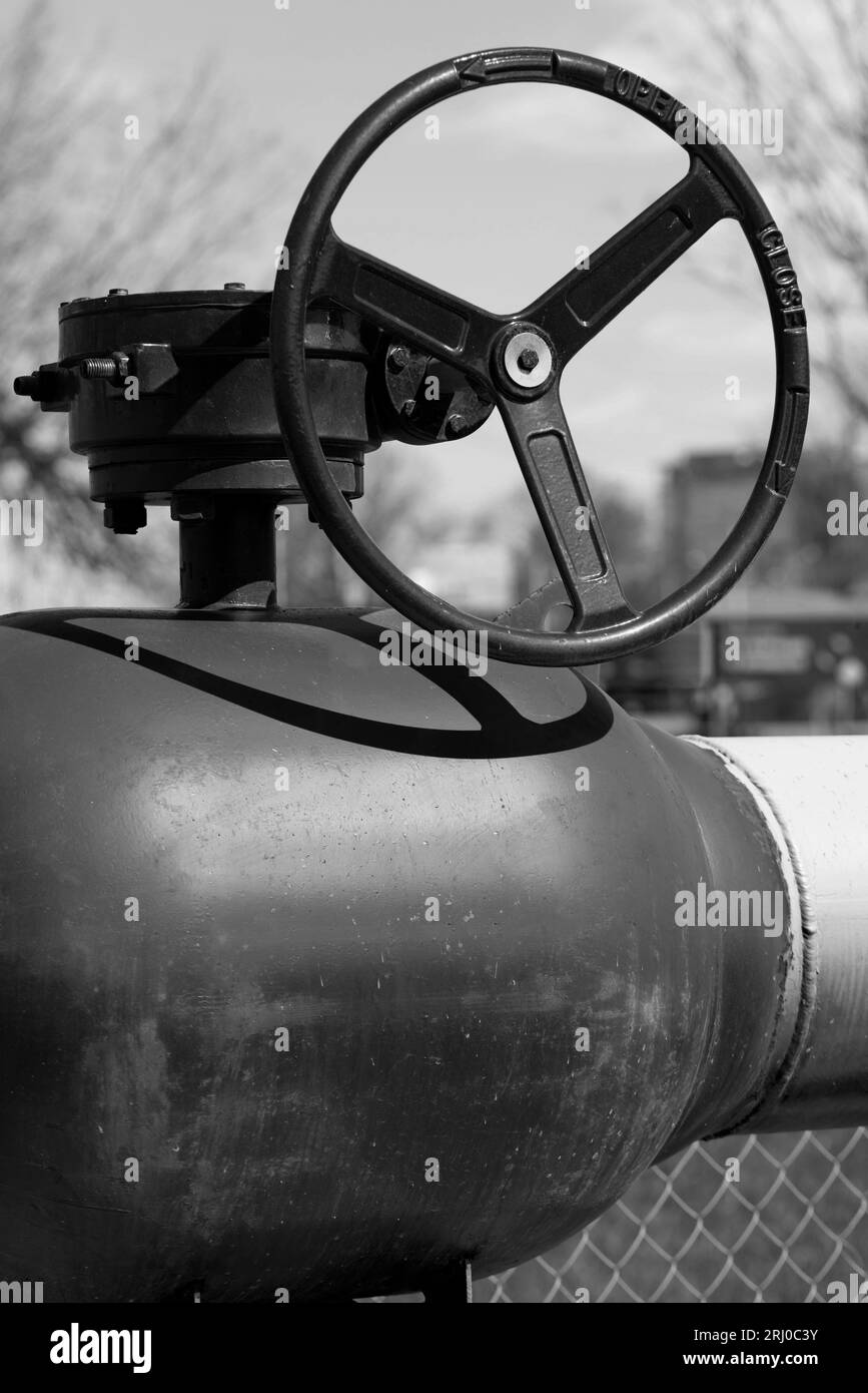 Yellow gas pipe with valve. Transportation, delivery of gas to consumers. Manual shut-off valve service with pipeline gas. Gasification land plots. Th Stock Photo