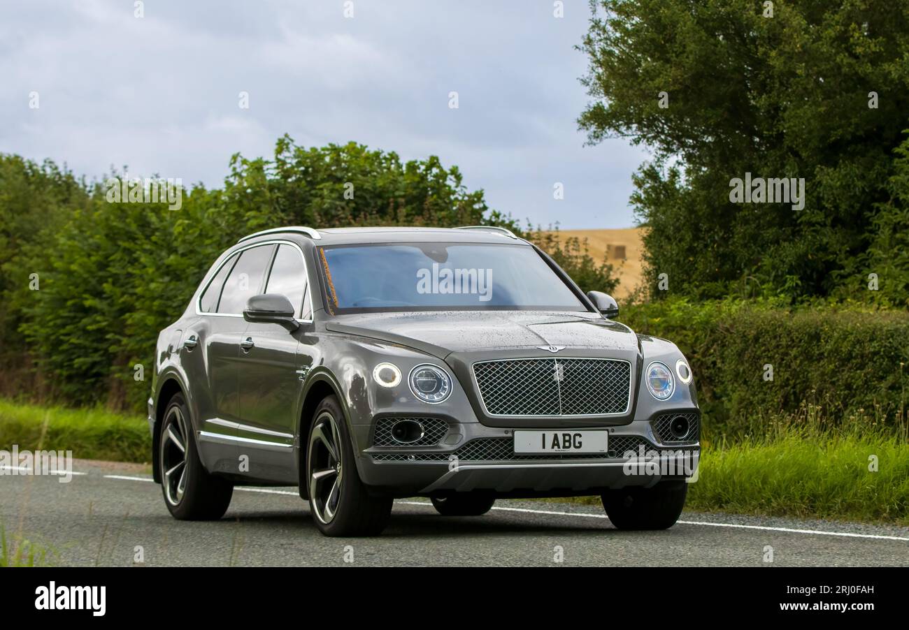 Woburn, Beds, UK - Aug 19th 2023:  Grey 2018 Bentley Bentayga SUV car travelling on an English country road. Stock Photo