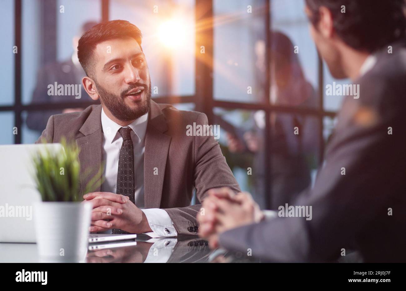 Two medium focused business workers communicate in the office. Stock Photo