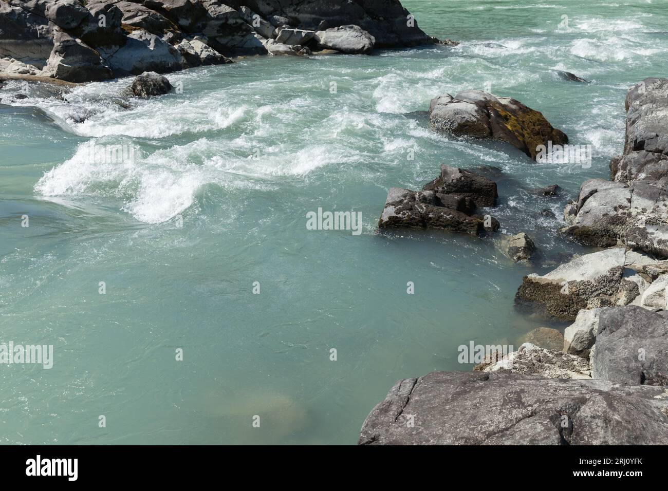 Fast water flowing between coastal rocks. Katun river. Altai Republic, Russia Stock Photo