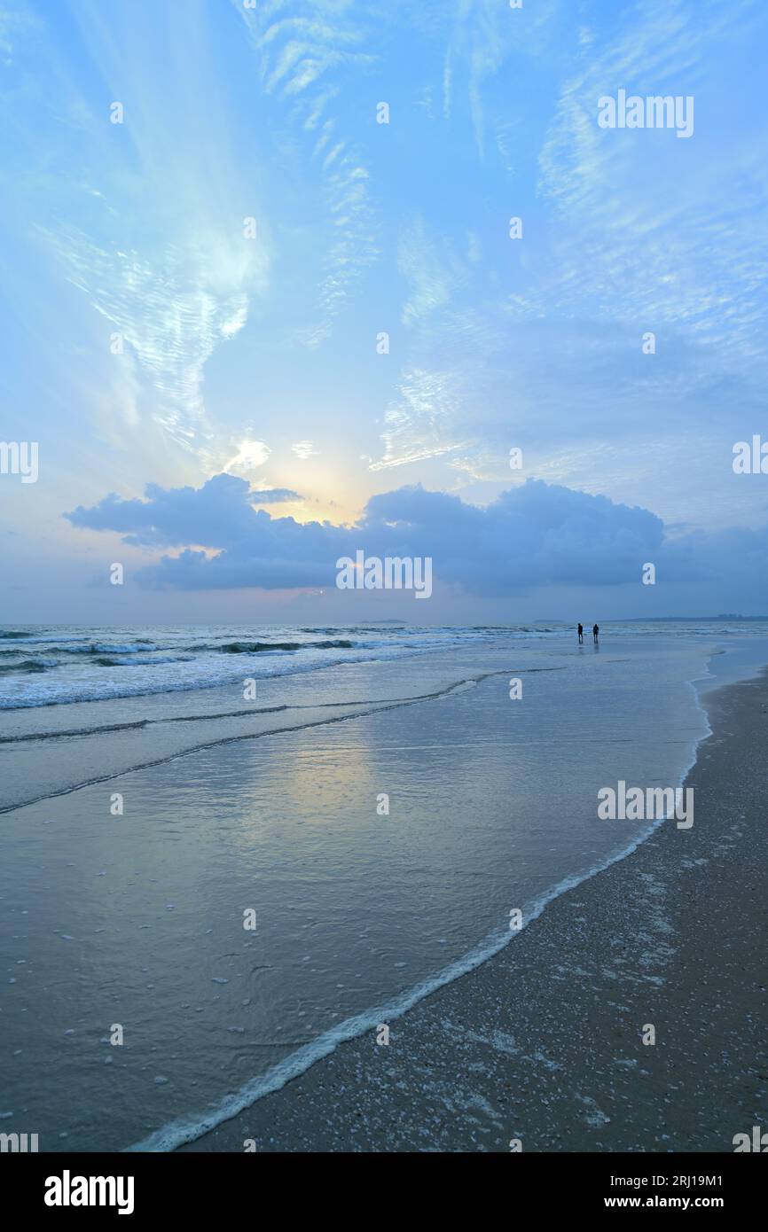 South Goa | Tiny waves on the beach under dusky clouds Stock Photo
