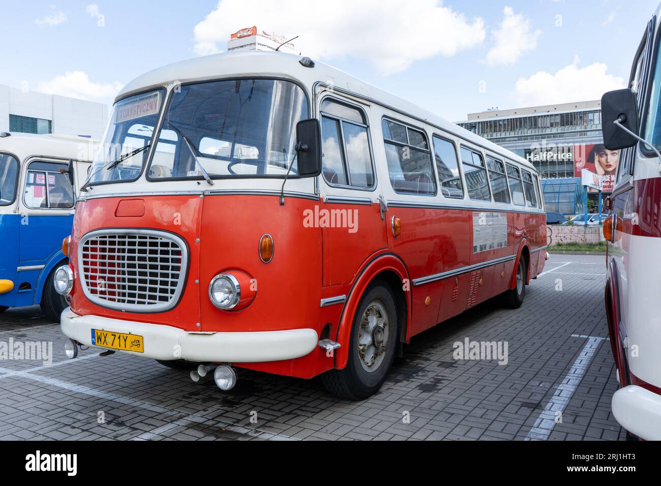 The old red and blue Skoda bus. Czechoslovakian Skoda RTO 706 Karosa model. Tourist buses vintage model. The street of the old city is a tourist attraction. Poland, Warsaw - July 27, 2023. Stock Photo