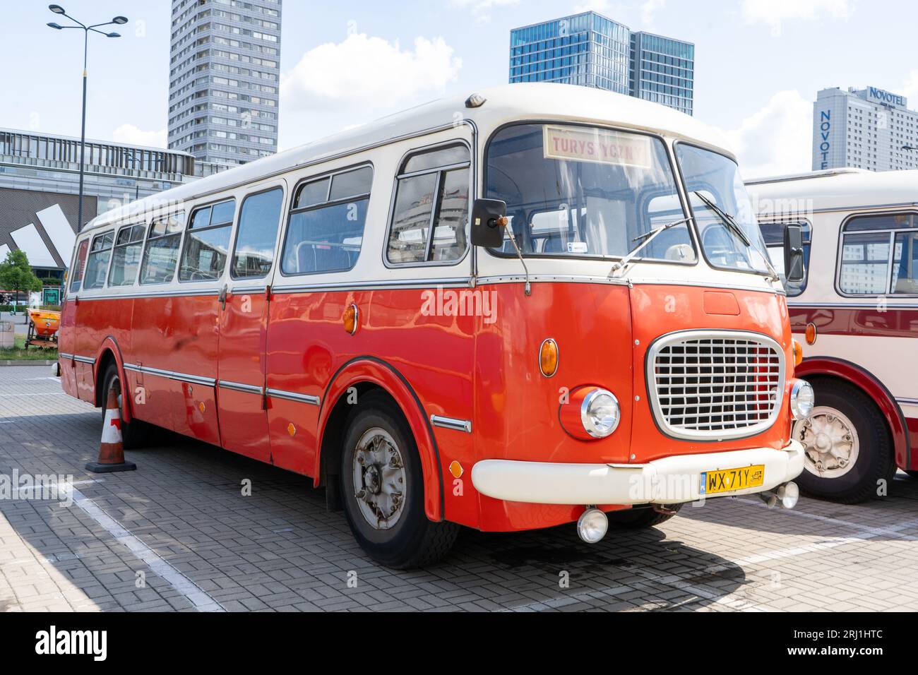 The old red and blue Skoda bus. Czechoslovakian Skoda RTO 706 Karosa model. Tourist buses vintage model. The street of the old city is a tourist attraction. Poland, Warsaw - July 27, 2023. Stock Photo