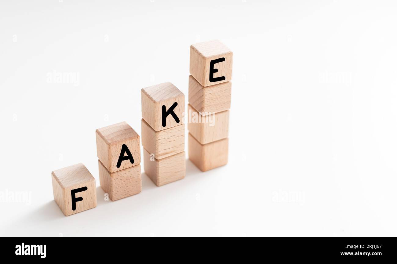 Word FAKE made with wooden cubes on white background Stock Photo - Alamy
