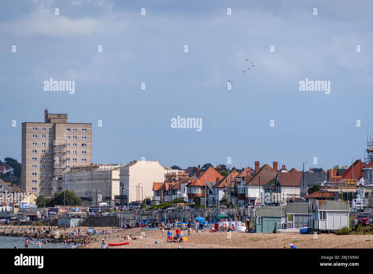 The Red Arrows can be seen at distance over the town of Herne Bay as they head to the Folkestone Airshow in 2023. Stock Photo