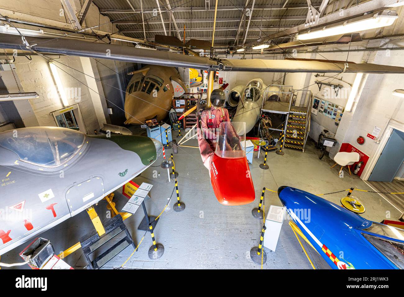 Interior, hanger at RAF Manston museum with a Pathfinder microlight hanging from ceiling, cockpit sections of a Victor bomber, Canberra and Buccaneer. Stock Photo