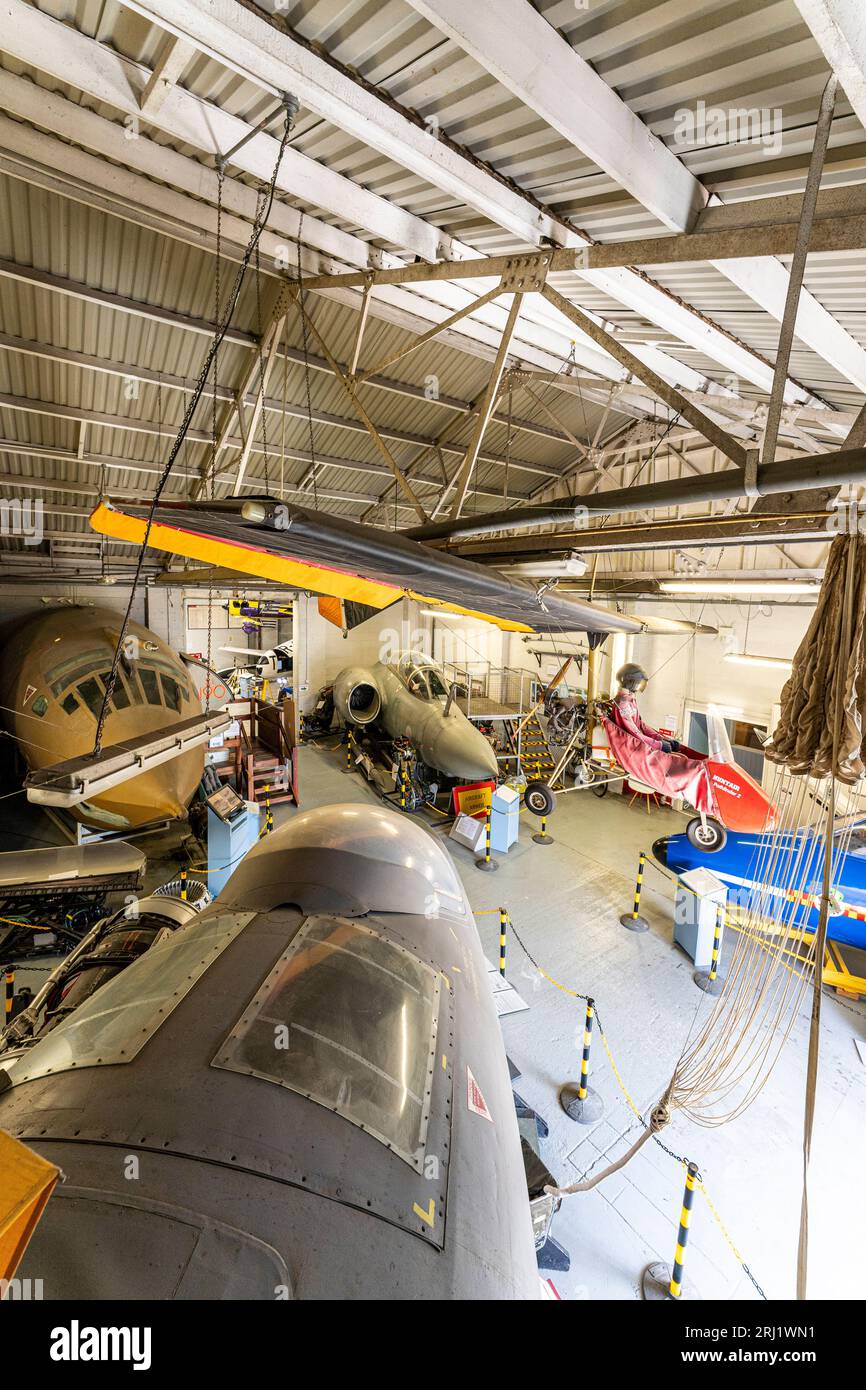 Interior, hanger at RAF Manston museum with a Pathfinder microlight hanging from ceiling, cockpit sections of a Victor bomber, Canberra and Buccaneer. Stock Photo