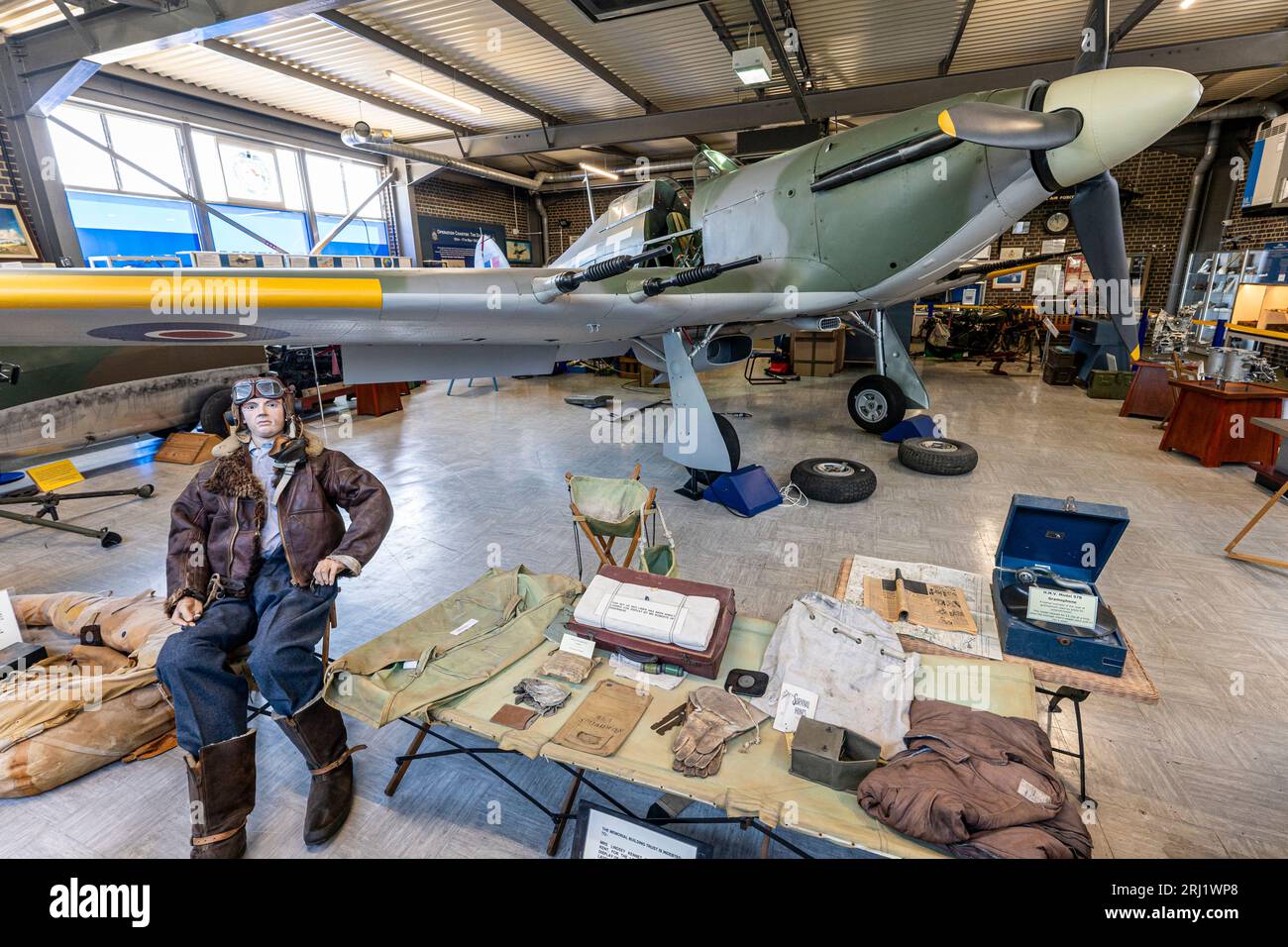 RAF Hurricane II on display inside the Spitfire and Hurricane museum at Manston in Kent. Low angle view of plane with pilot figure sitting outside. Stock Photo