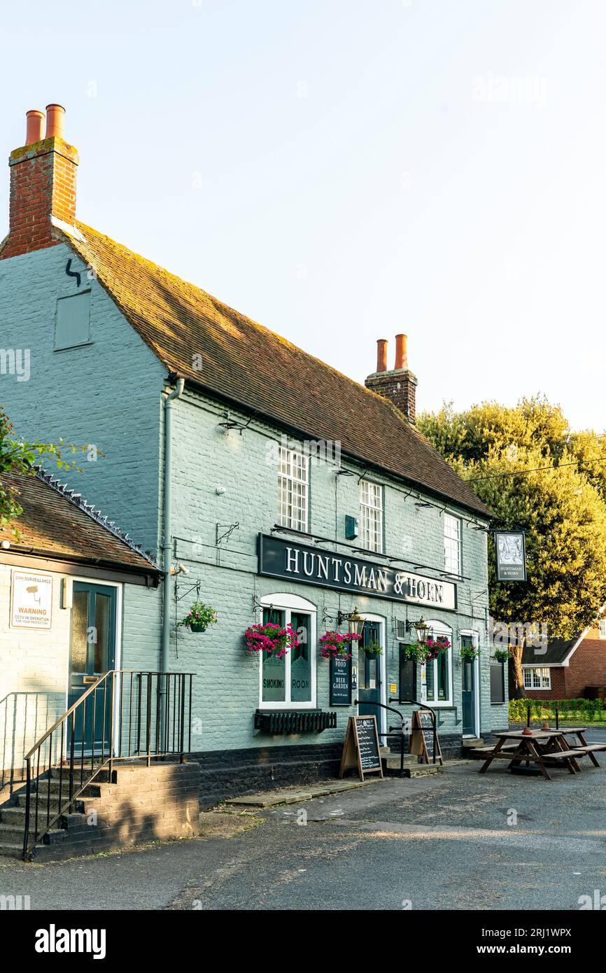 The 'Huntsman and Horn' village public house in Broomfield, Kent. 19th century green brick building with hanging baskets and menu boards outside. Stock Photo