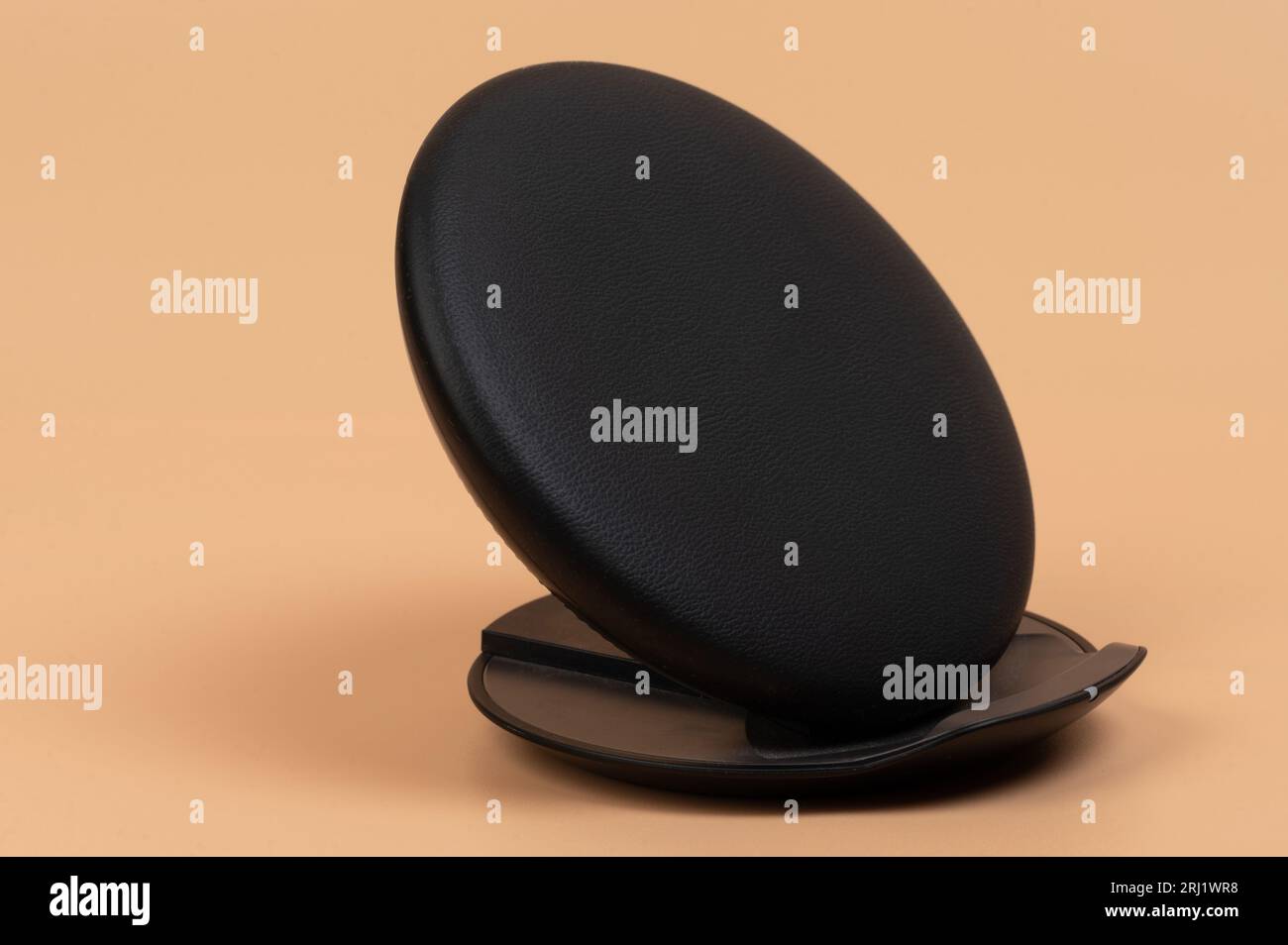 Leather wireless charger pad isolated on brown background Stock Photo