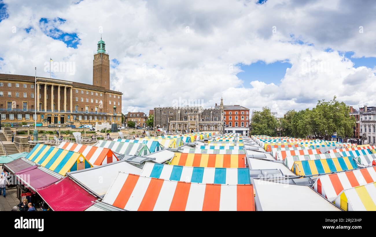 A multi image panorama featuring the striped rooftops of Norwich market, surrounded by Norwich City Hall and Norwich Guildhall in August 2023. Stock Photo