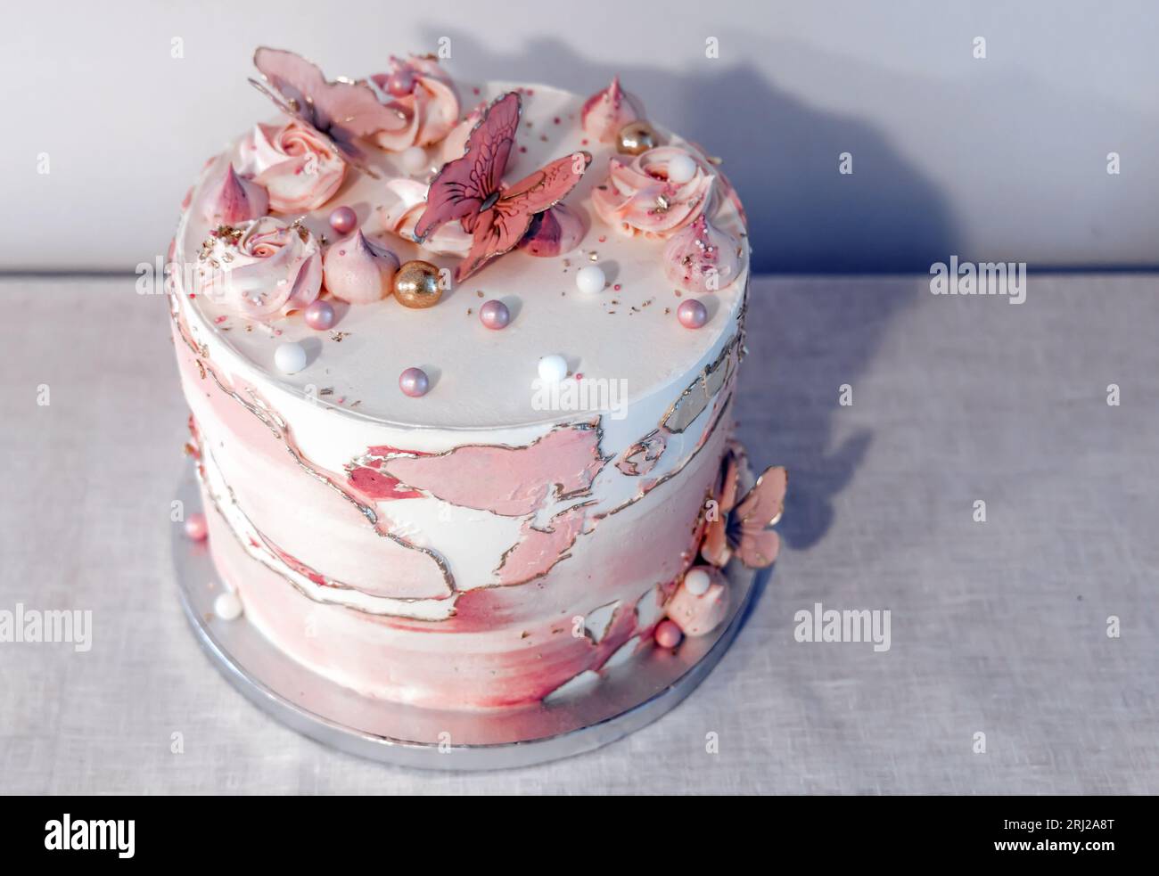 Birthday cake decorated with pink sugar flowers and butterflies Stock ...