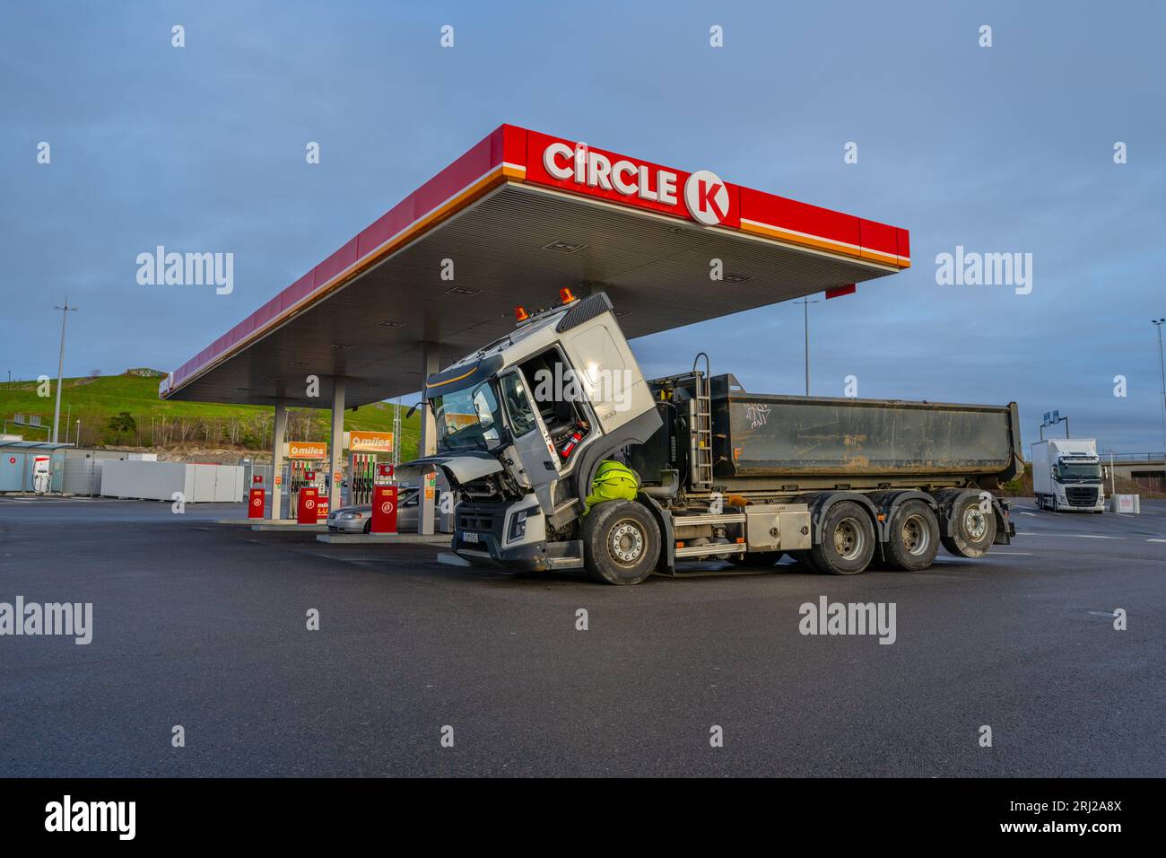 Gothenburg, Sweden - January 03 2023: Trucker checking the fuel filter of a large dump truck at a Circle K gas station Stock Photo