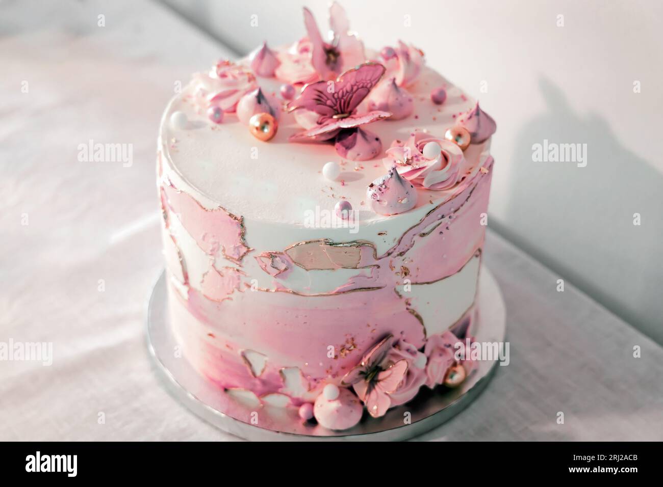 Birthday cake decorated with pink sugar flowers and butterflies Stock ...