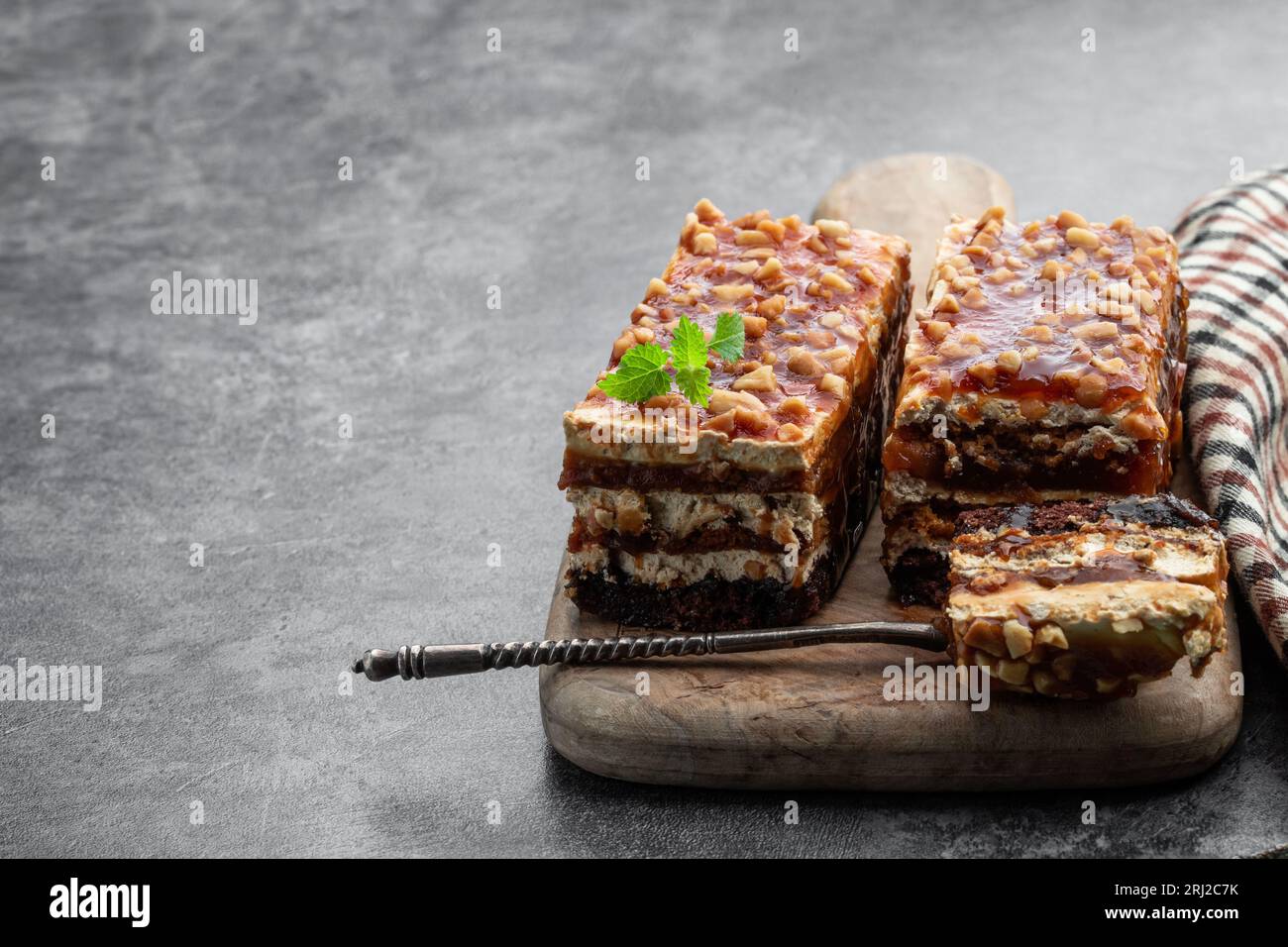 Layered  cake with caramel cream and nuts on gray background Stock Photo