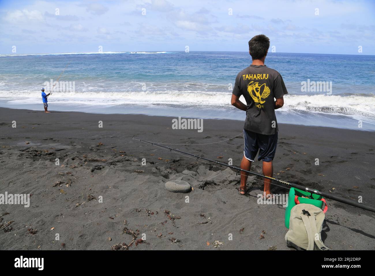 Pêche à la ligne sur la plage de sable noir volcanique de Papara à Tahiti en Polynésie française. Cette plage de Taharuu est connue pour ses belles va Stock Photo