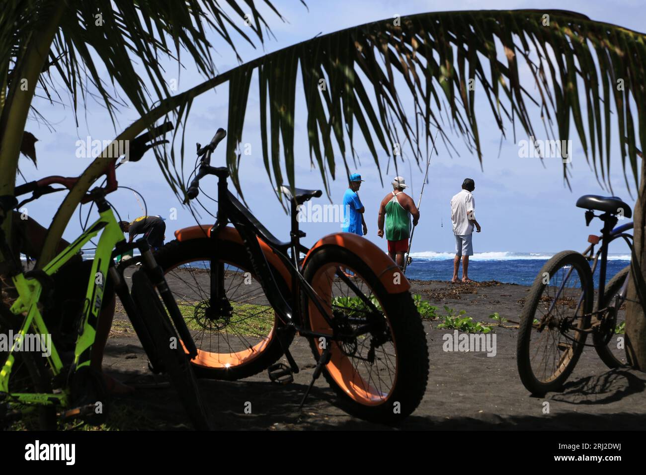 Pêche à la ligne sur la plage de sable noir volcanique de Papara à Tahiti en Polynésie française. Cette plage de Taharuu est connue pour ses belles va Stock Photo