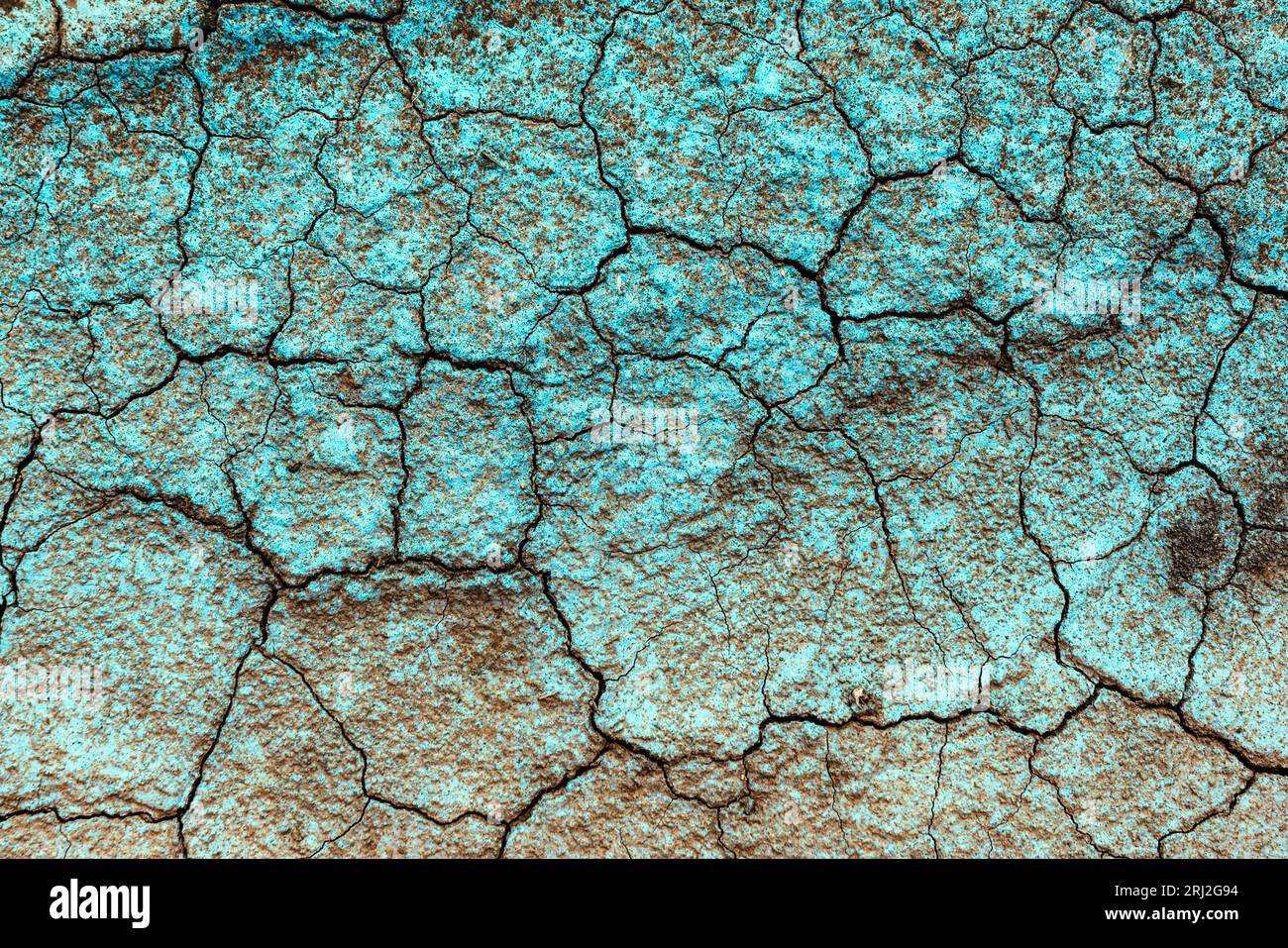 Blue copper fungicide on dry cracked ground as background, top view