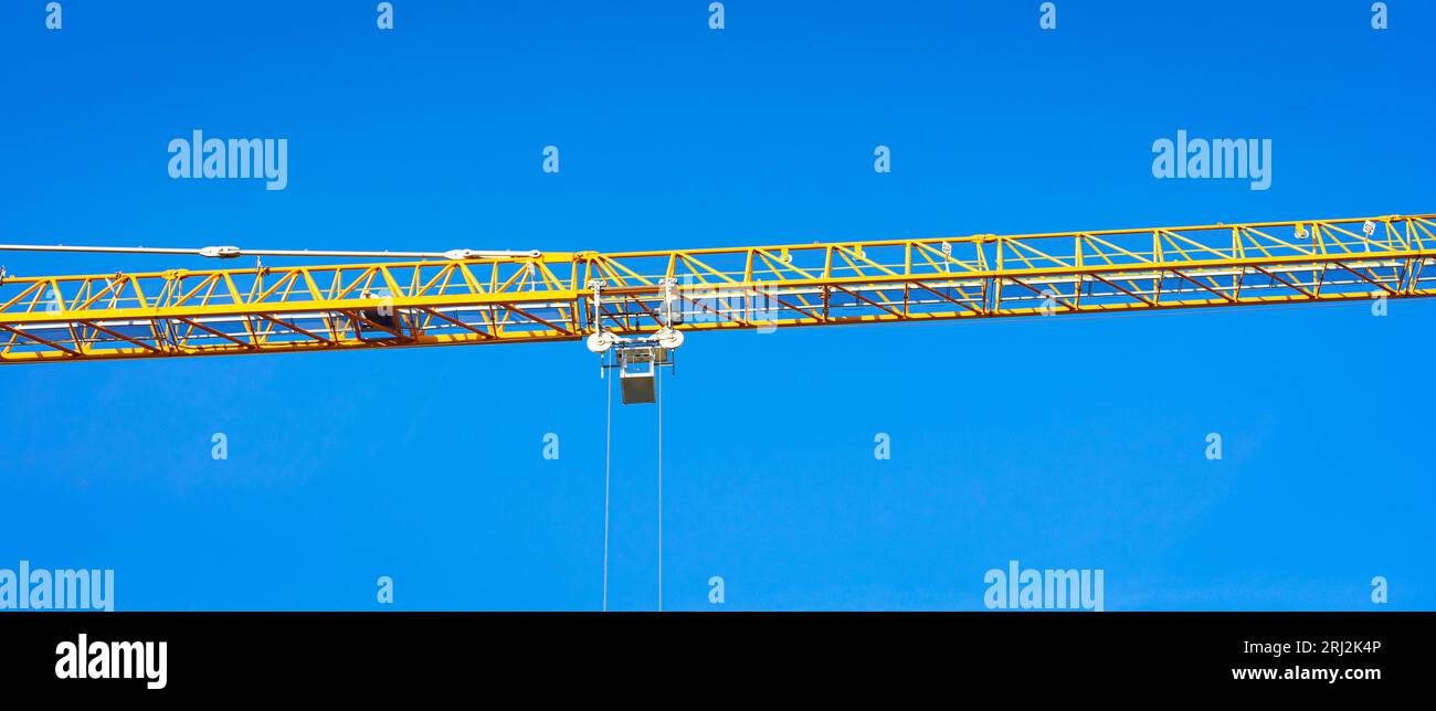 Yellow colored middle part of a crane against a blue sky as background Stock Photo