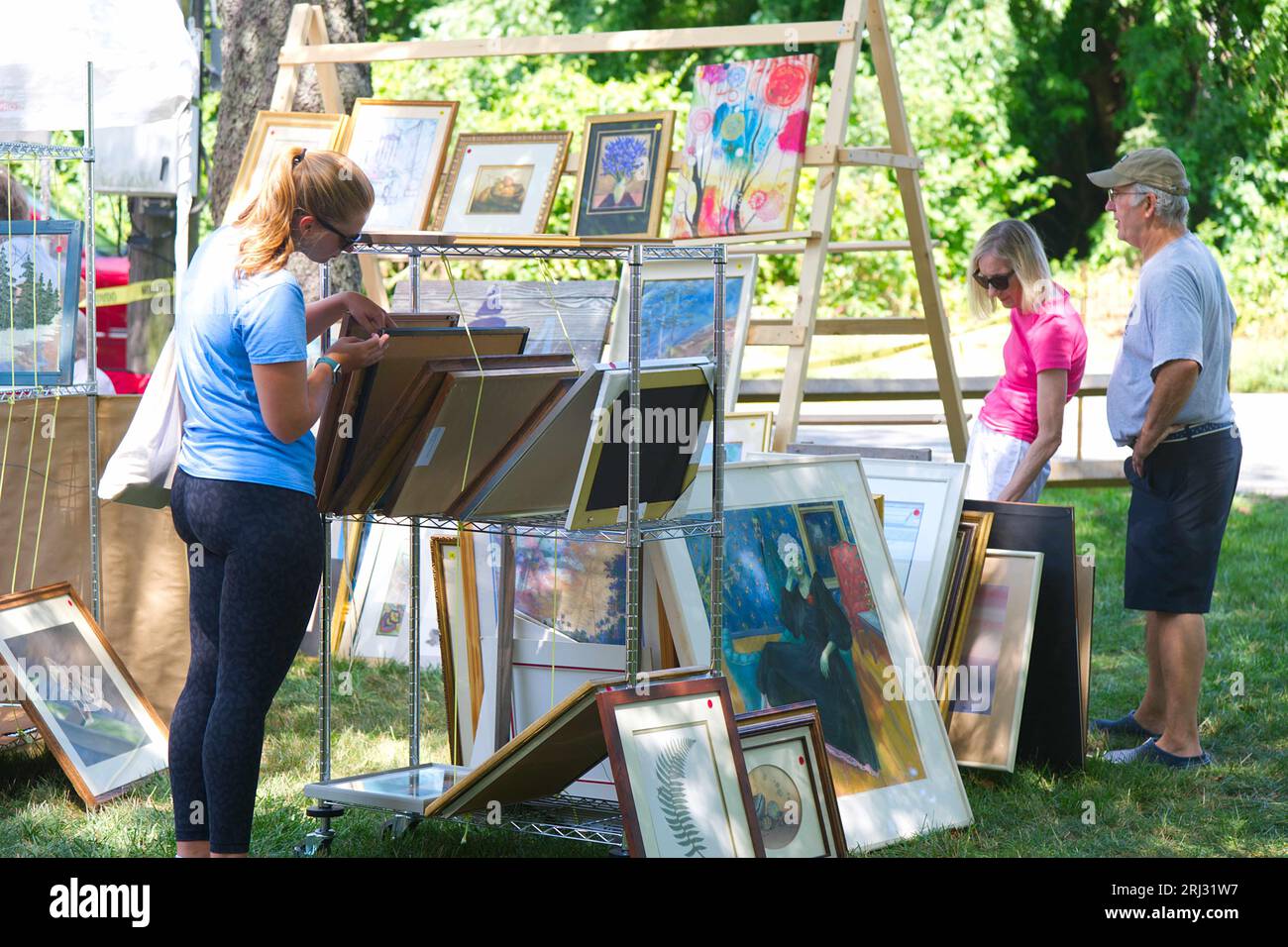Examining art at an annual church fair and flea market, Dennis, Massachusetts, on Cape Cod, USA Stock Photo