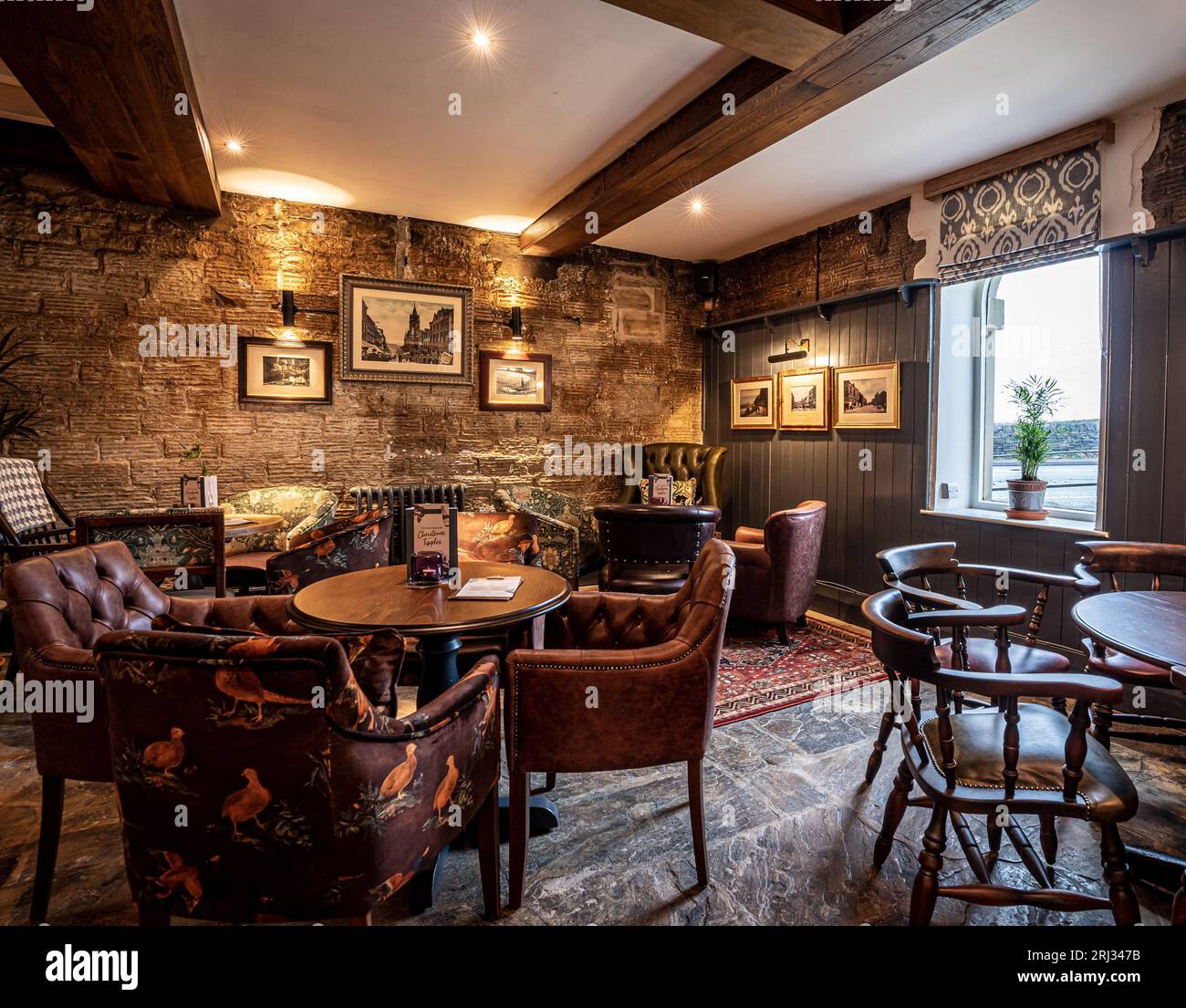 This interior view of a traditional Tudor-style pub offers a warm and cozy atmosphere Stock Photo
