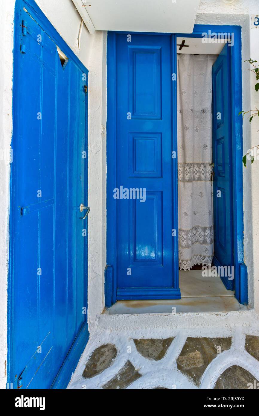 Entrance of a traditional house of typical Cycladic architecture with blue doors and white walls, in Mykonos island, Cyclades islands, Greece, Europe. Stock Photo