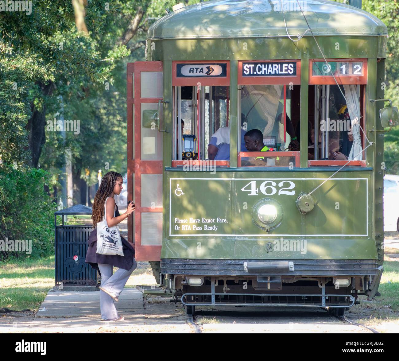 NEW ORLEANS, LA, USA - AUGUST 18, 2023: Woman boarding historic St. Charles Line streetcar at the corner of S. Carrollton Avenue and Oak Street Stock Photo