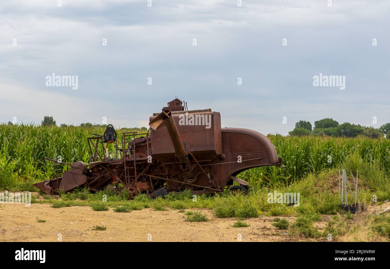 Old abandoned agricultural machinery rusting in the field Stock Photo