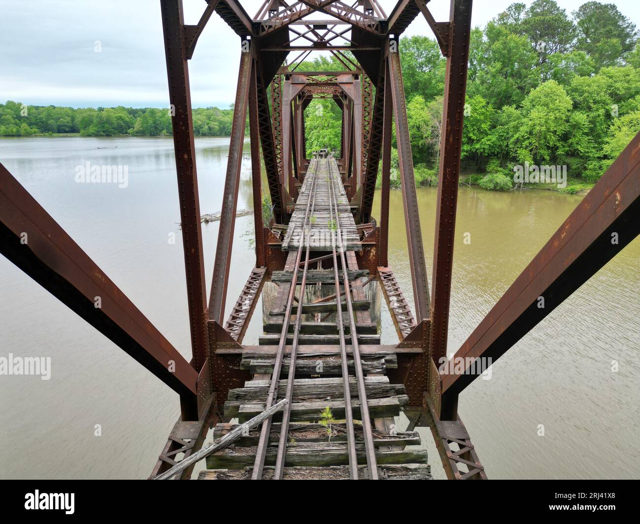 A scenic view of a railroad bridge, spanning across a peaceful lake Stock Photo