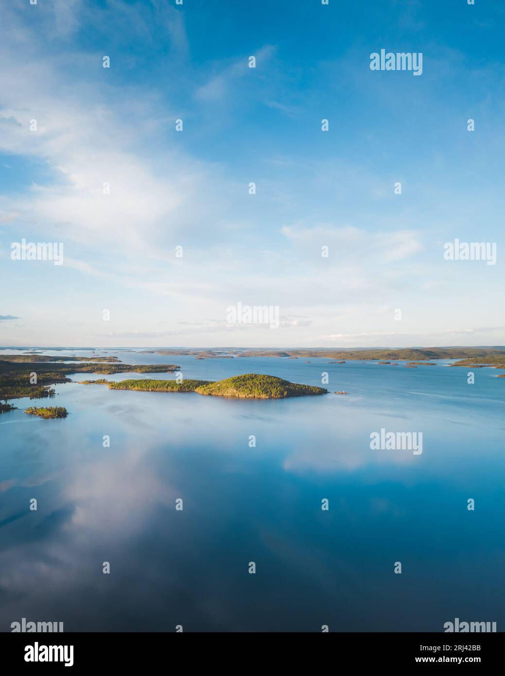 An aerial view of a tranquil lake surrounded by vibrant green ...