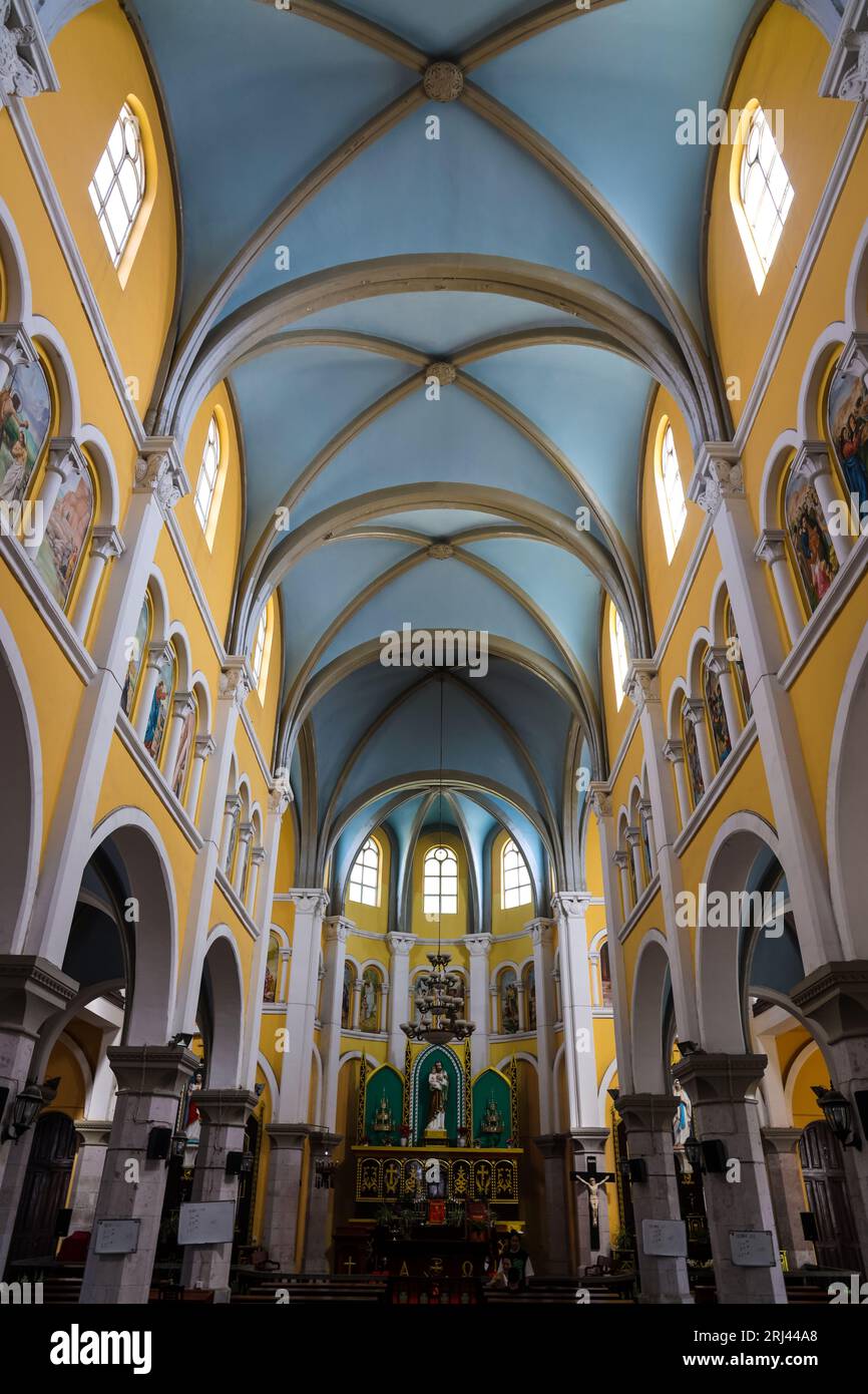 A cathedral with high vaulted ceilings, grand pillars and a small altar Stock Photo