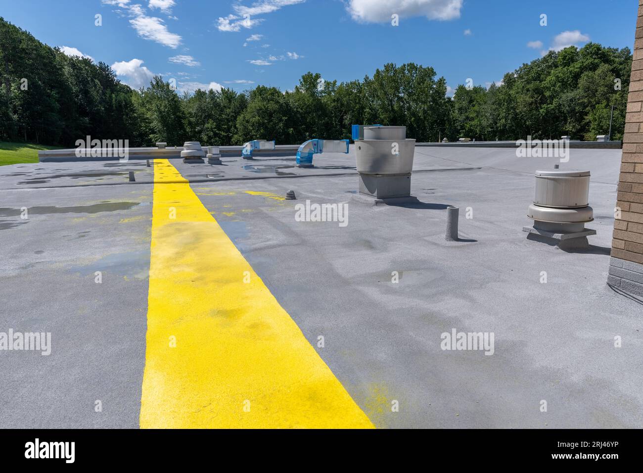 Painted safety yellow walkway on new spray foam roof for foot traffic