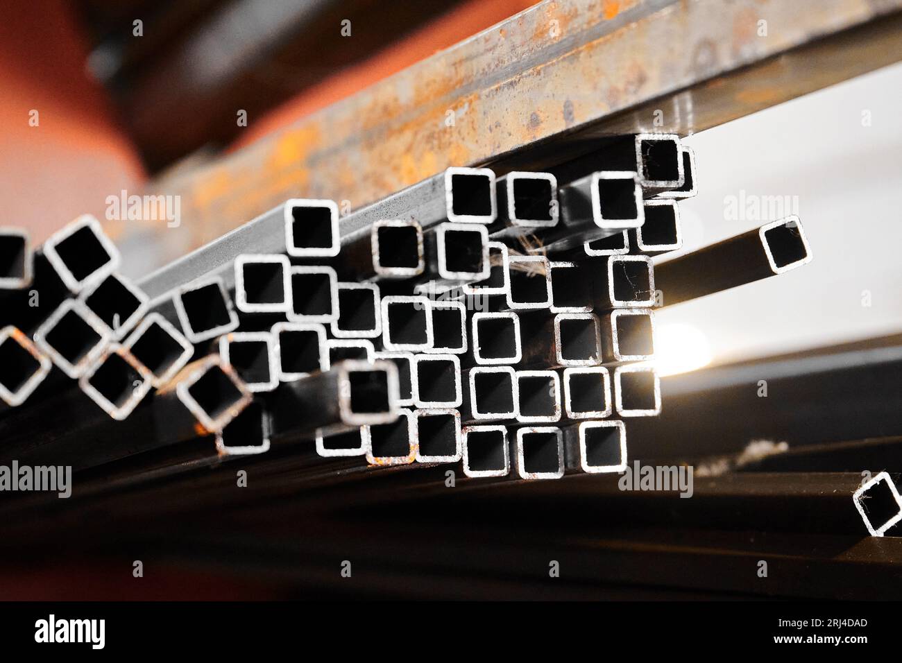 Square tubing on blurred background in cold warehouse Stock Photo - Alamy