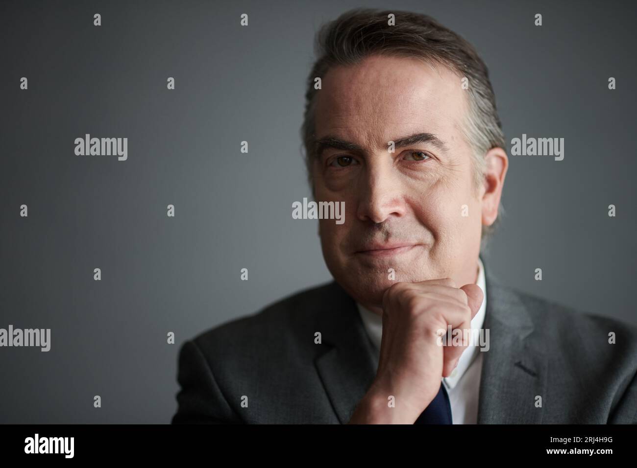 Studio portrait of smiling mature entrepreneur in grey suit Stock Photo ...