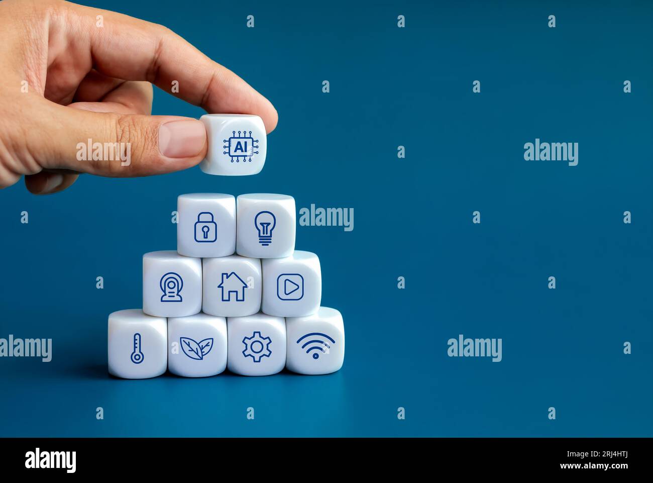 AI technology and smart home technology concepts. Artificial intelligence icon in human hand put on top of triangle shape blocks stack with home digit Stock Photo