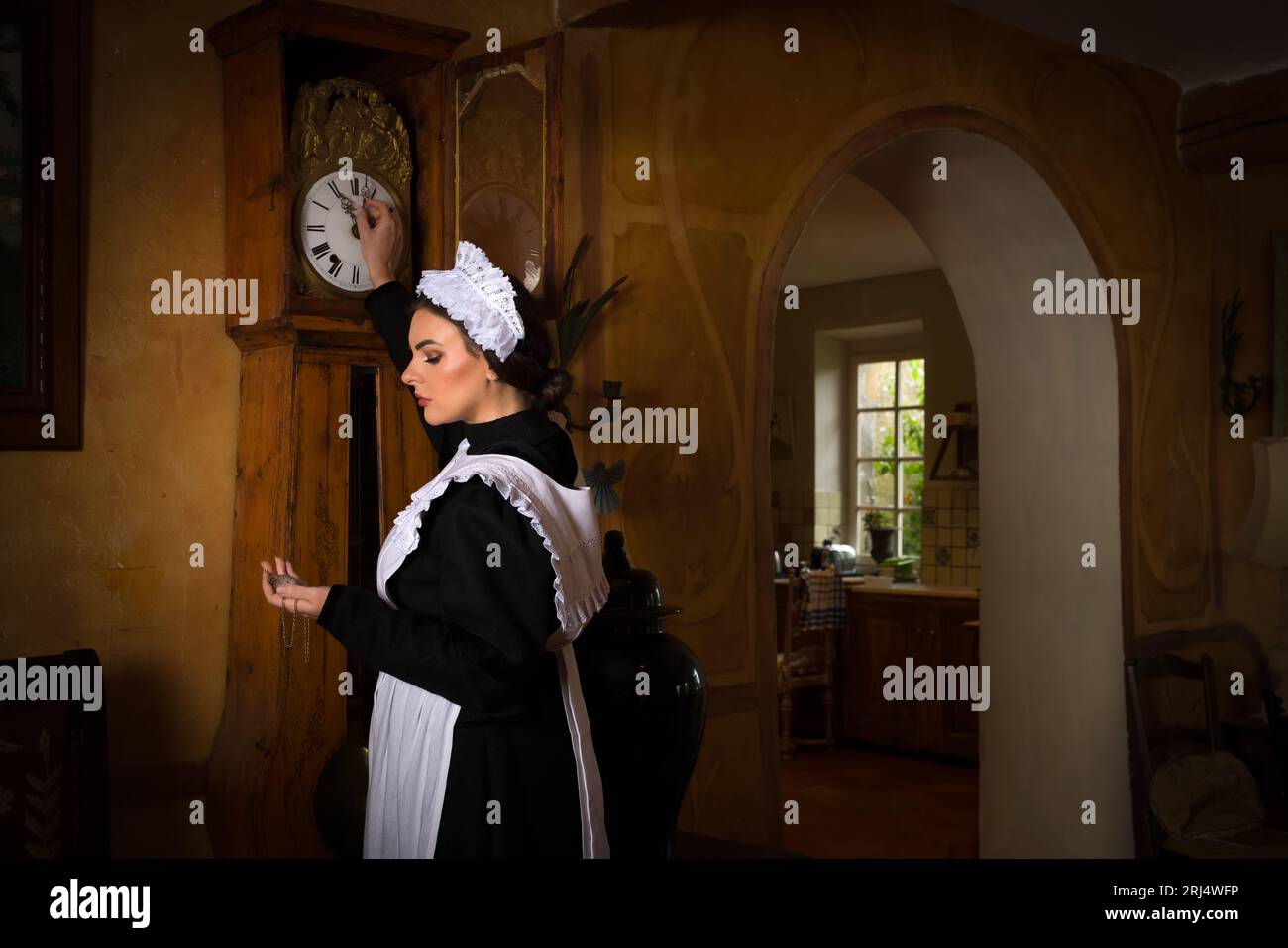 Scenes of a beautiful young Victorian maid doing house chores in an antique interior Stock Photo