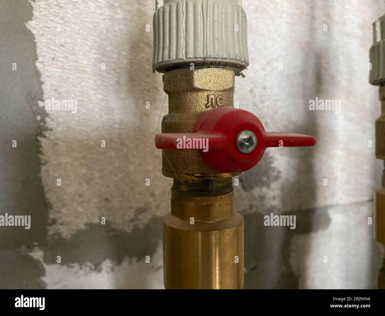 Closeup many copper and sewer gray plastic pipes, red valves, fittings, water counters. Concept