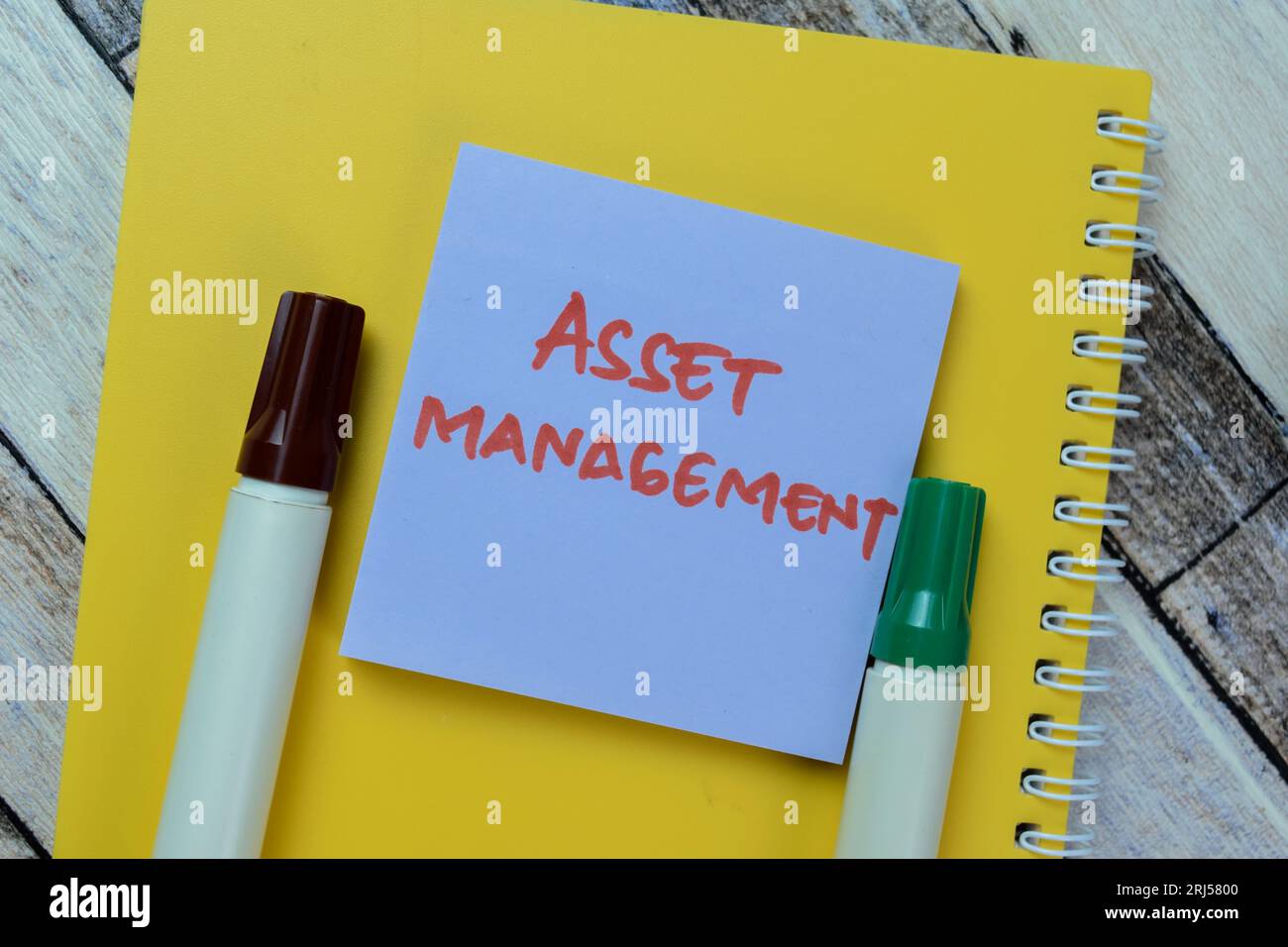 Concept of Asset Management write on sticky notes isolated on Wooden Table. Stock Photo