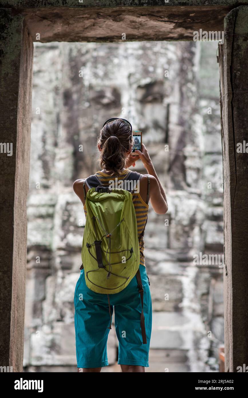 A female tourist taking pictures at Bayon, ankor Thom temple, Angkor Wat, Siem Reap, Cambodia. Stock Photo