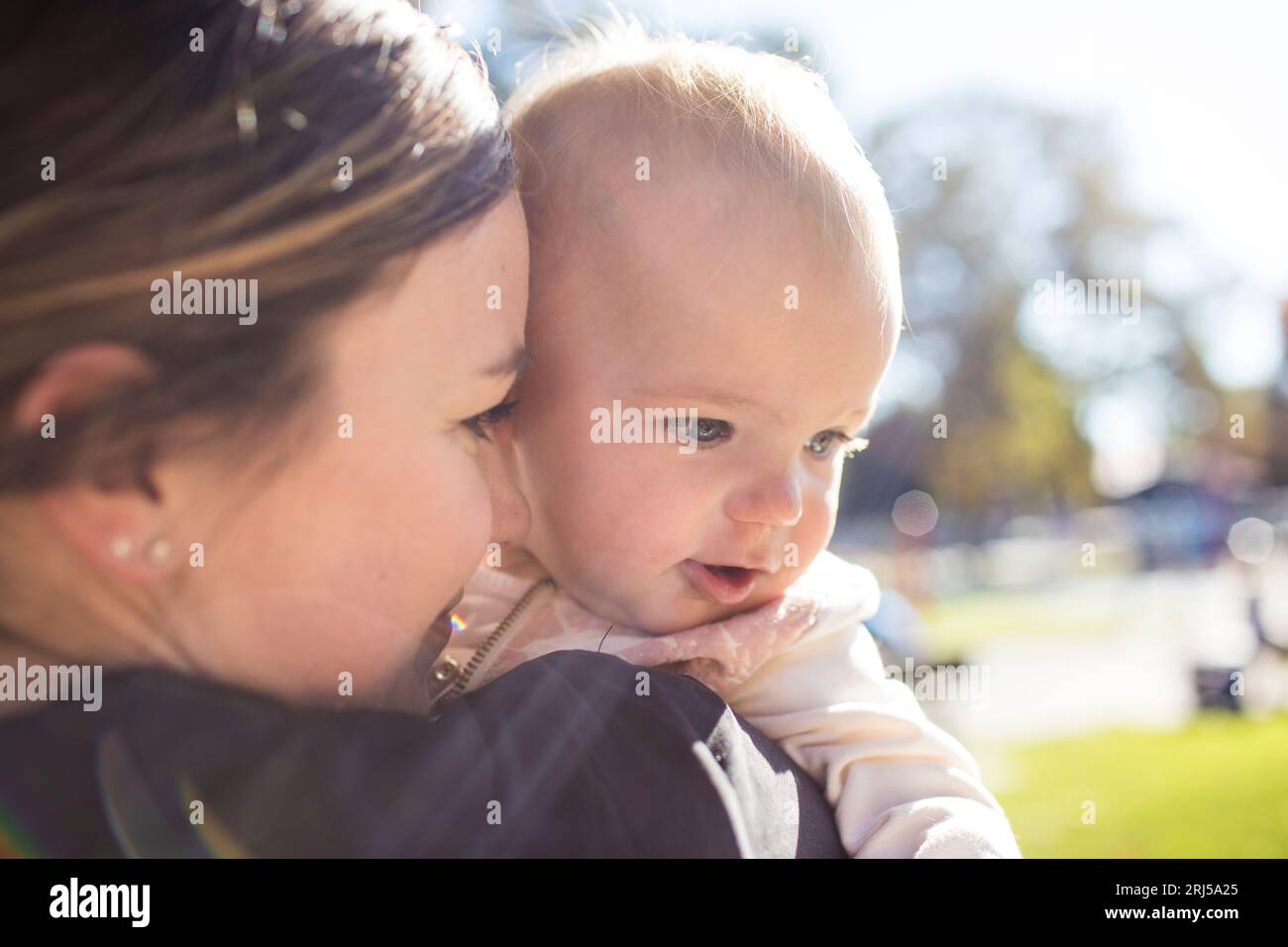 Close up of Mother holding her daughter at the park. Stock Photo