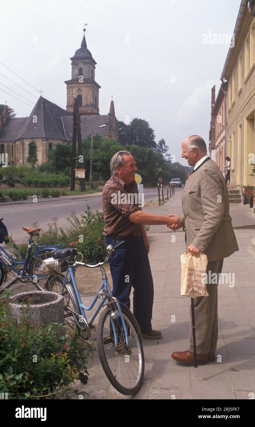 Boitzenburg, East Germany 6th June 1990.  Count Adolf-Heinrich Graf von Arnim returns to the family estate and Boitzenburg castle for the first time in 45 years. His aim to claim back his inheritance from East Germany government. The Count meets up with Willie, an old friend in the village main street, he has not seen since he left 45 years ago.  1990s HOMER SYKES Stock Photo