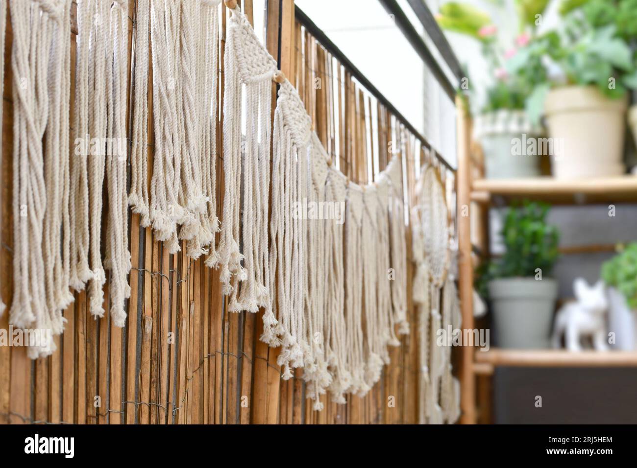 Hanging Reeds Makramee garland hanging on balcony reed screen Stock Photo - Alamy