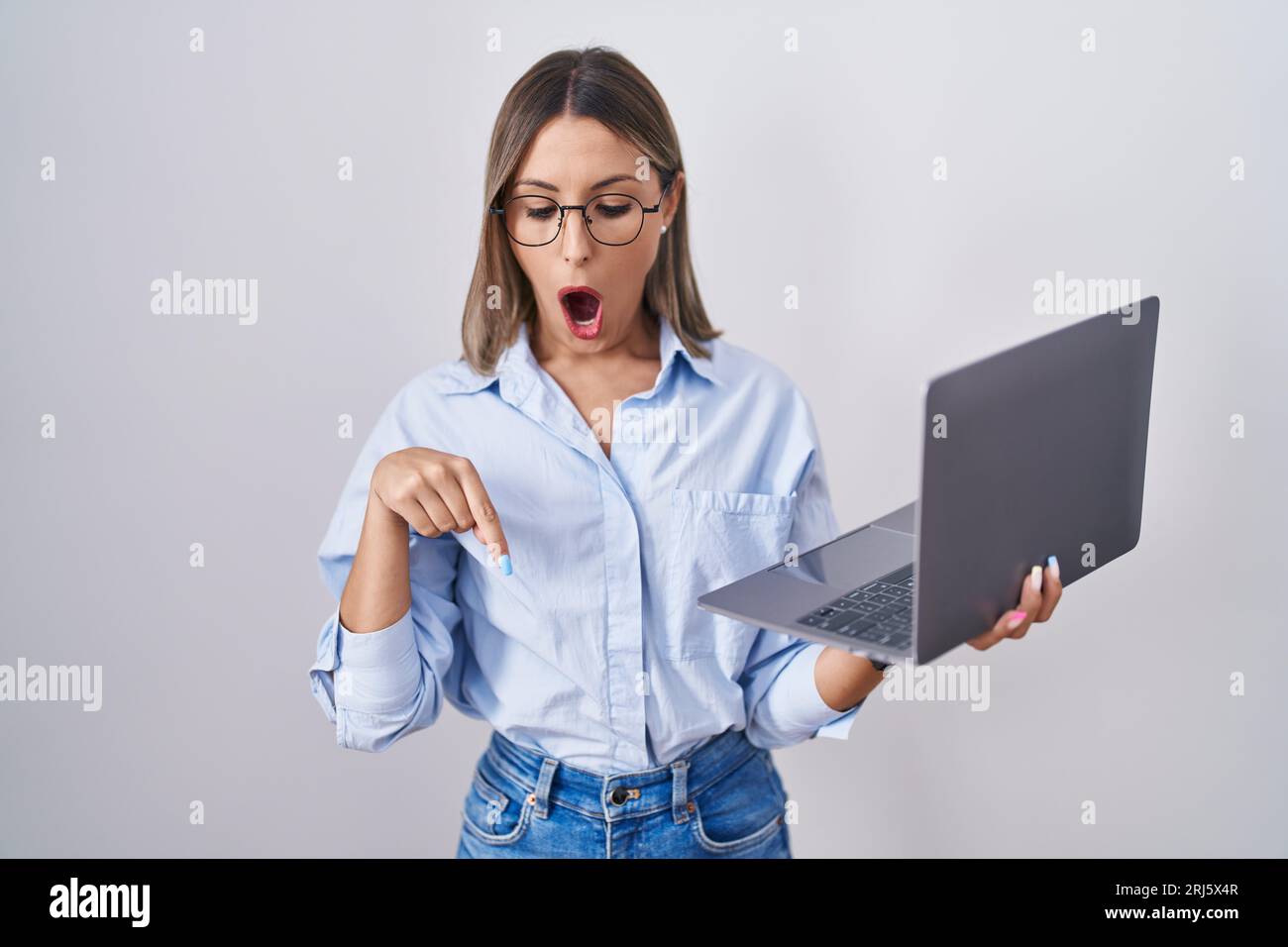 Young woman working using computer laptop pointing down with fingers ...