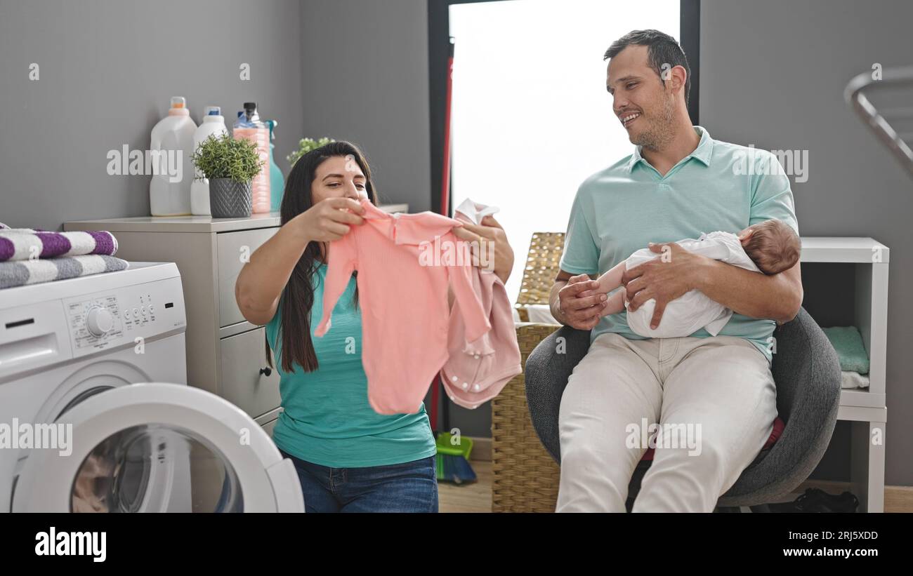 Family of three washing clothes at laundry room Stock Photo