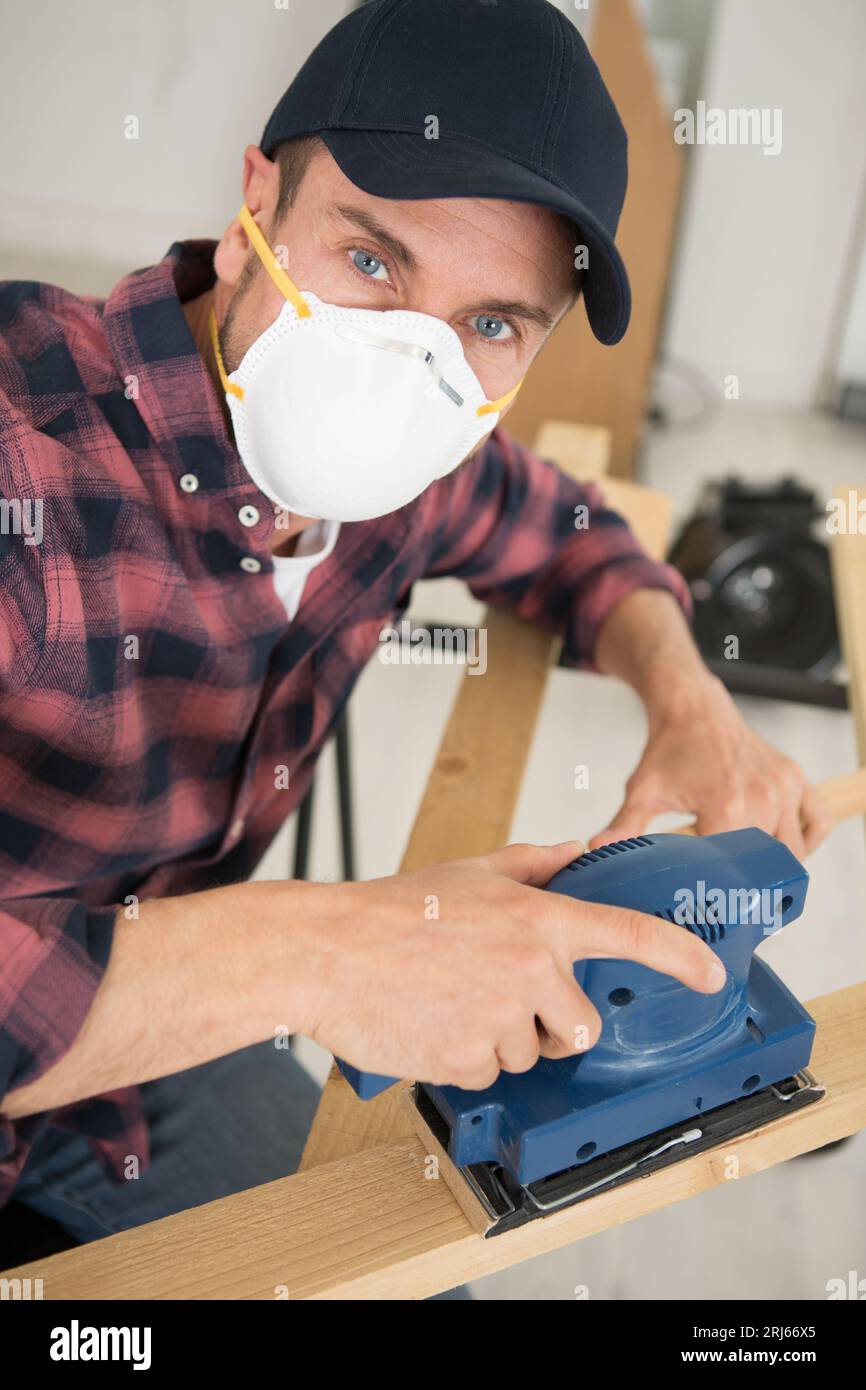 man is sanding a wood block with a sanding block Stock Photo