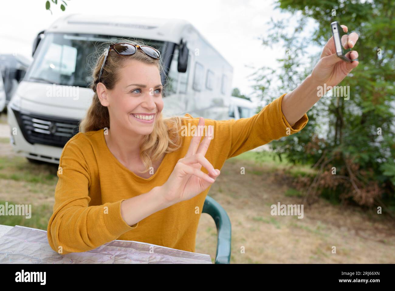 beautiful happy woman sitting by the van in the nature Stock Photo
