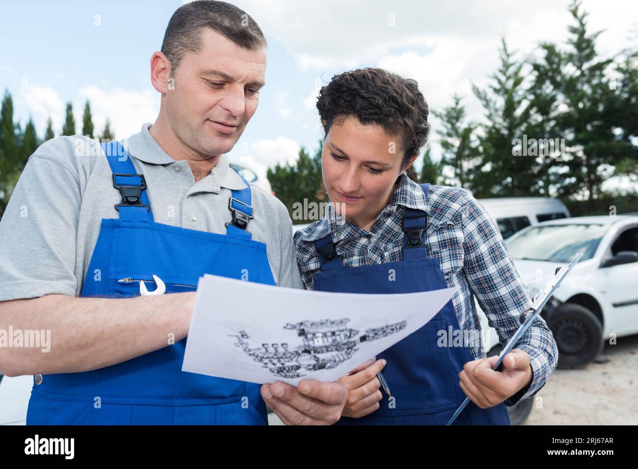 mechanic and female apprentice looking at exploded diagram Stock Photo