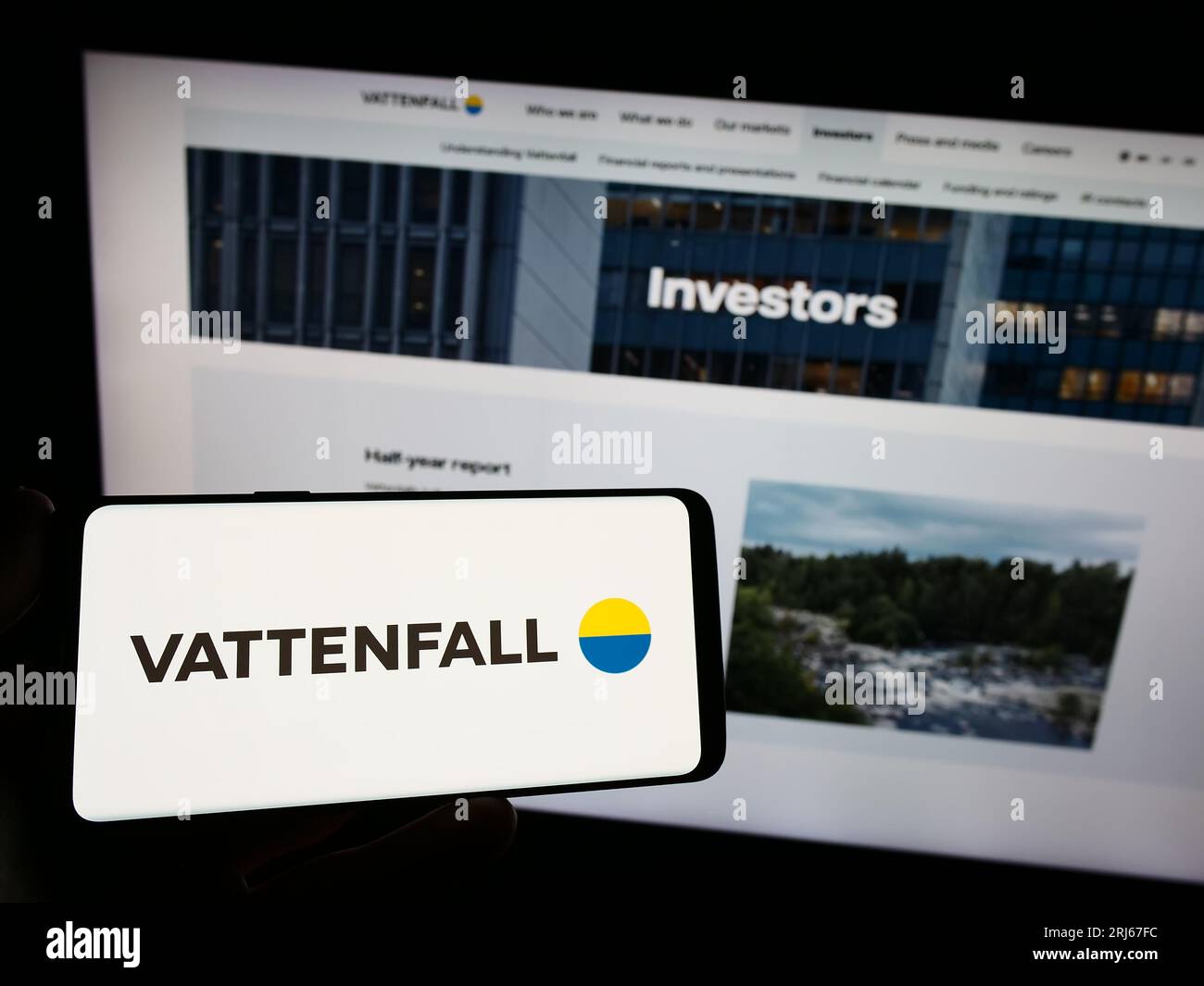 Person holding smartphone with logo of Swedish energy company Vattenfall AB on screen in front of website. Focus on phone display. Stock Photo